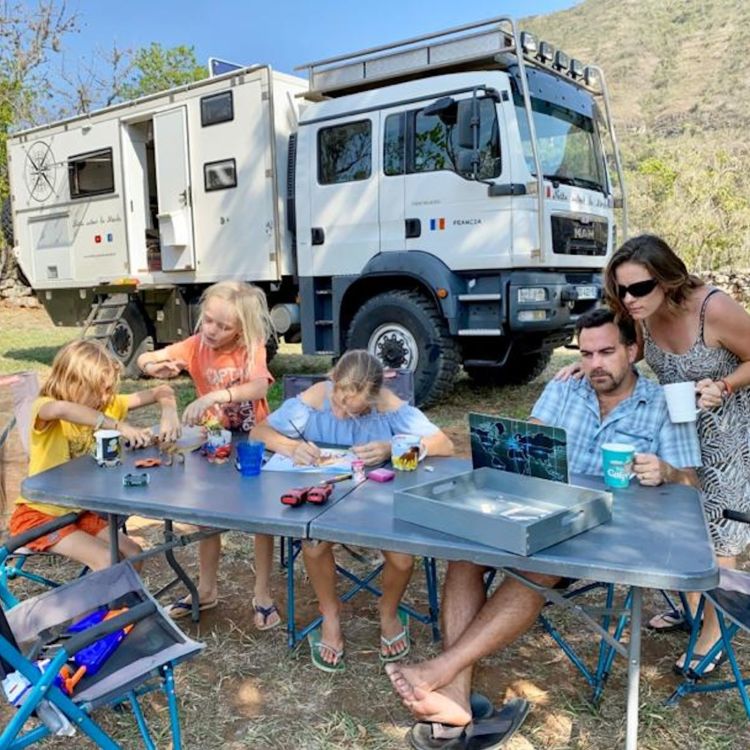 Famille autour d'un camion de voyage